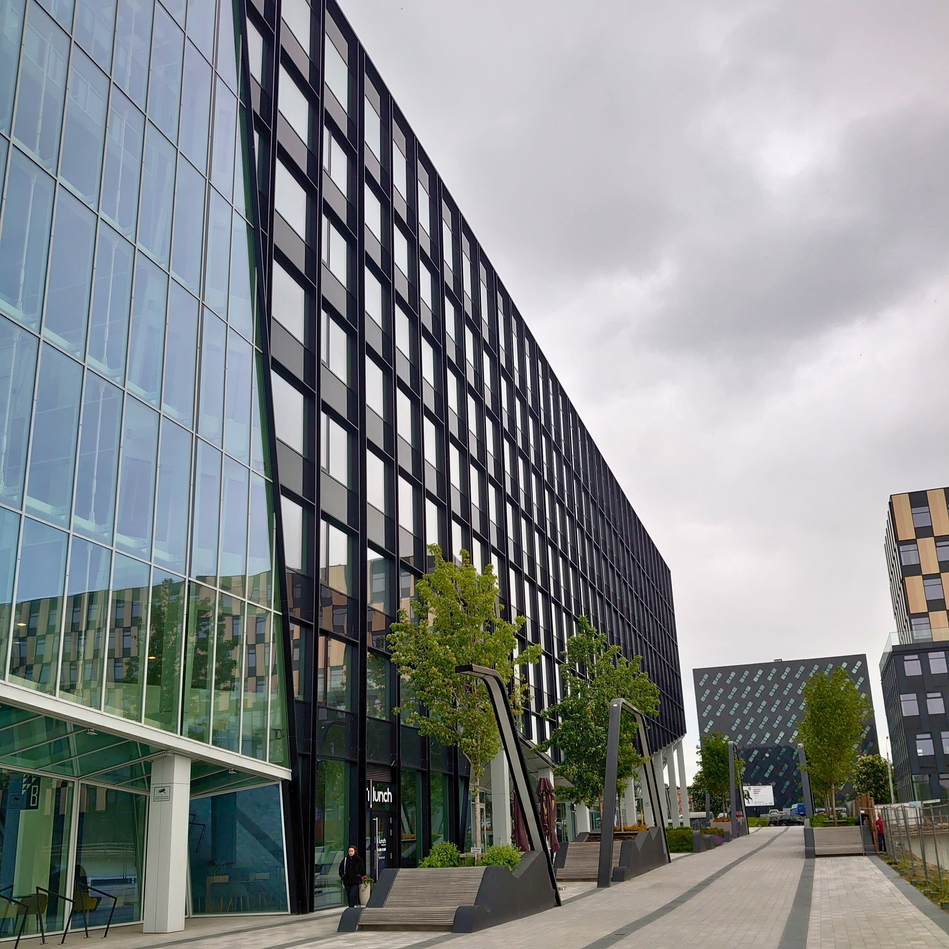  Didelis daugialangis pastatas, pabrėžiantis statybos įmonės fasado montavimo projektą.