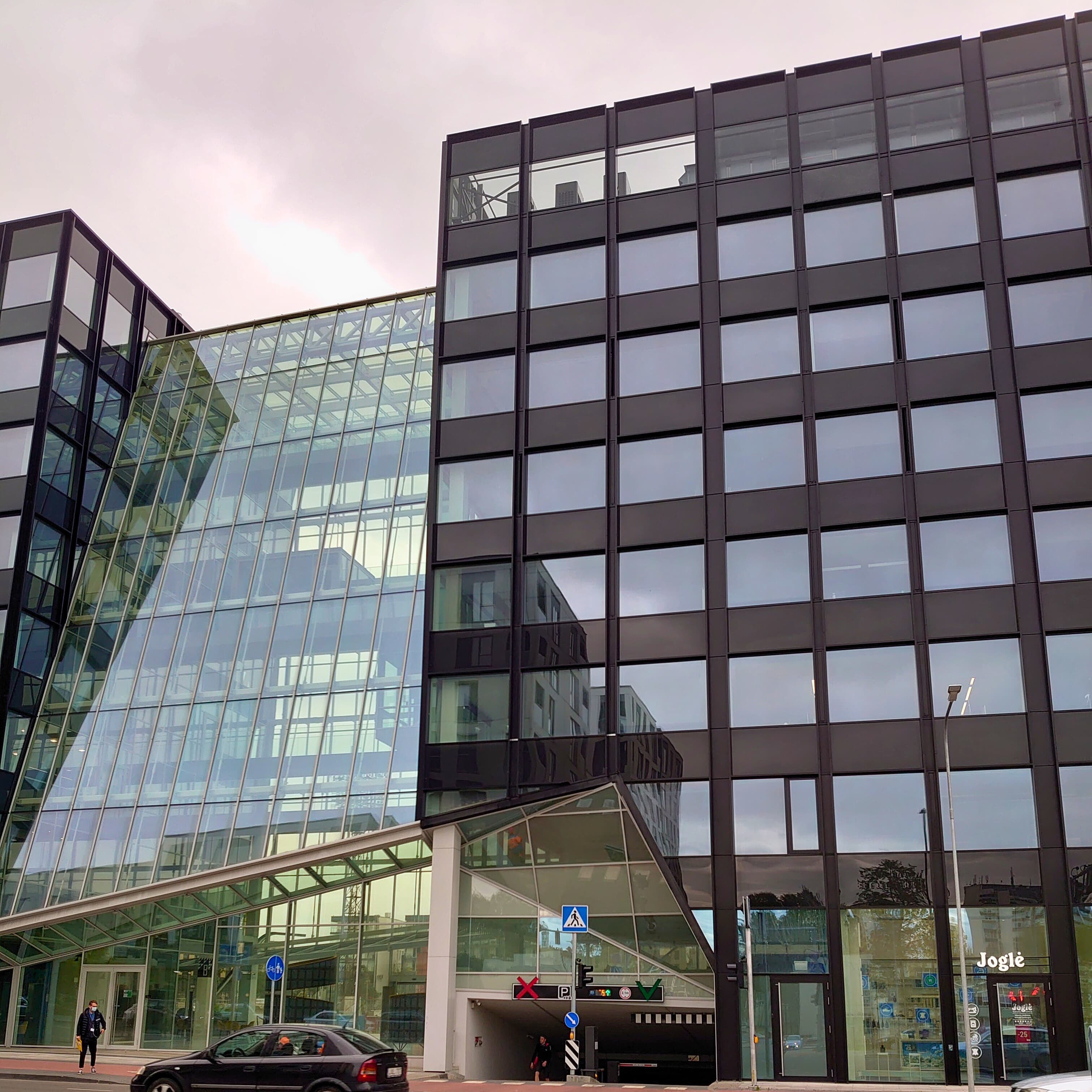 Erdvus pastatas su daugybe langų, atspindintis statybos įmonės dėmesį stiklo fasadų montavimui.
