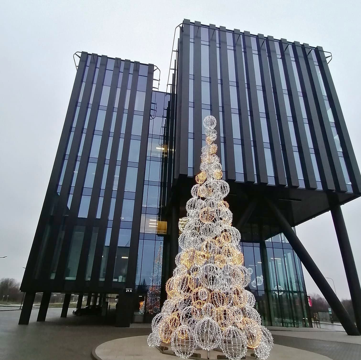 Platus pastatas su daugybe langų, reprezentuojantis statybos įmonės specializaciją stiklo fasadų montavime.